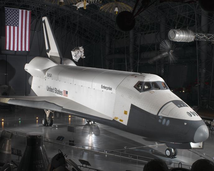 Side view of white and black space shuttle on display at the museum.