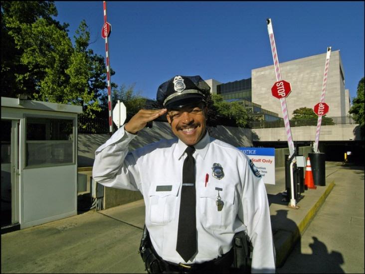 Darrell King, a security officer, smiles and performs a salute in front of the National Air and Space Museum's flagship building on the National Mall.