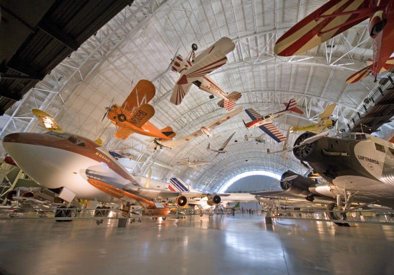 A hangar at the Steven F. Udvar-Hazy Center featuring several aircraft displayed from the ceiling or from the floor.