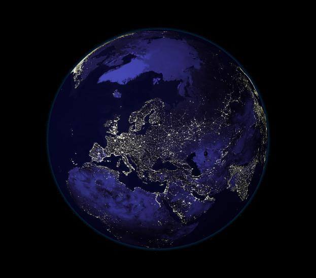 A satellite view of Earth during nighttime hours, with a focus on Europe and Northern Africa which has many lights visible from space.