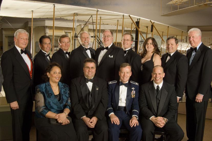 Former Museum Director Jack Dailey, Awards Master of Ceremonies David Hartman, N. Wayne Hale, Jr., and members of the STS-121 team stand together for a group photo at an awards ceremony.