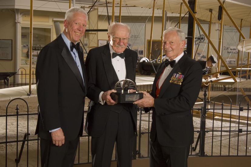 Former Museum Director Jack Dailey, pilot Robert "Bob" Hoover, and Awards Master of Ceremonies David Hartman stand together at an awards ceremony.