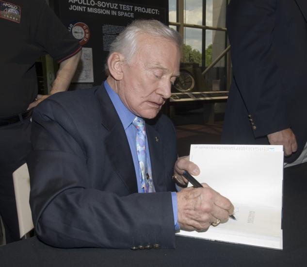 Buzz Aldrin signs book for a fan