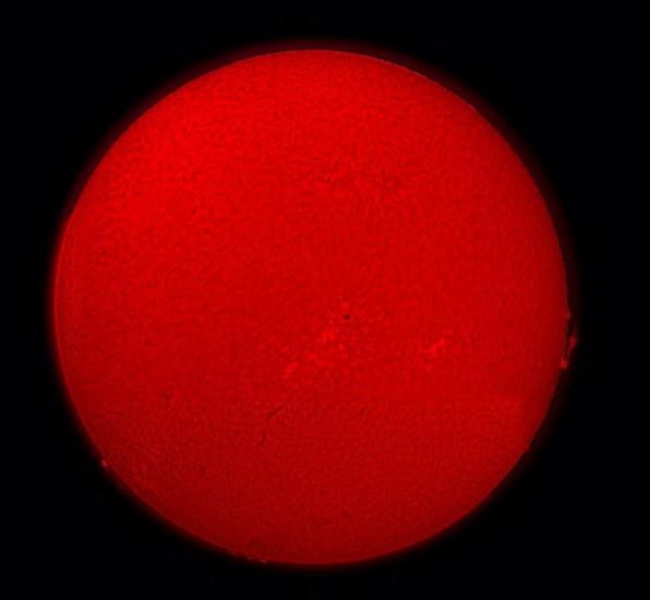 A semi-sphere view of the Sun with sunspots and granulation surface details.