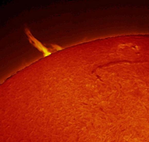 Partial view of the Sun which highlights a large prominence of plasma.