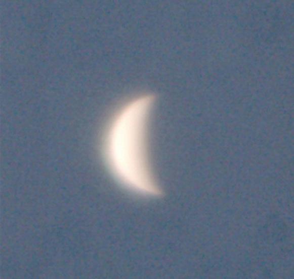 View of Venus as a waning crescent during daytime hours.