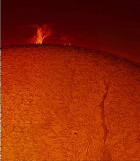 View of the Sun focused on a large prominence of plasma floating away from the Sun and a snake-shaped filament on the disc.