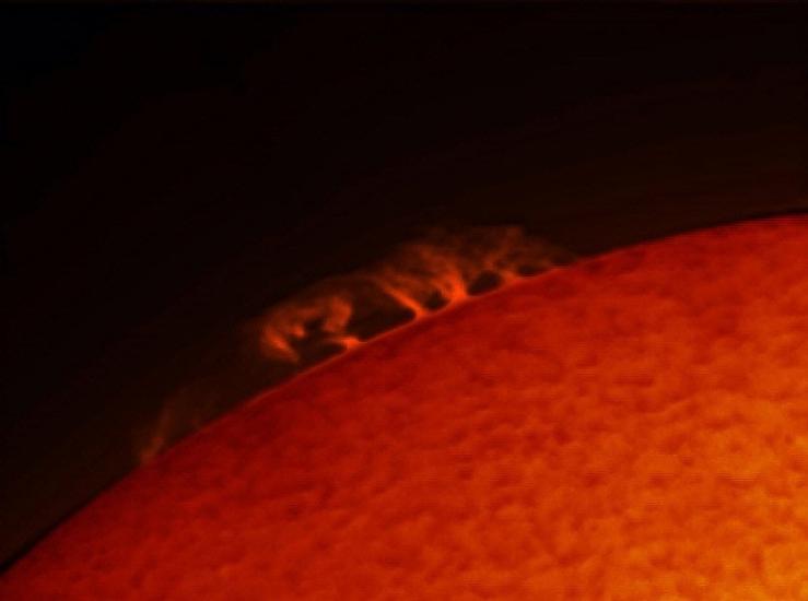 A part of the sun with prominences of plasma floating from the top of the sphere