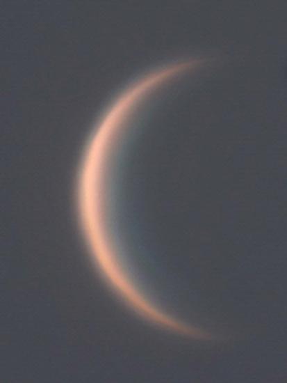 View of Venus as a thin waxing crescent during daytime hours.