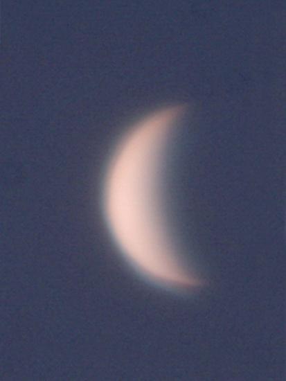 View of Venus as a waxing crescent in the daytime sky.