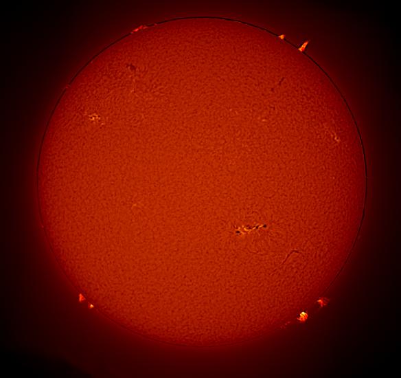 Disc view of the sun, with multiple prominences of plasma floating away from the Sun as well as sunspot clusters.