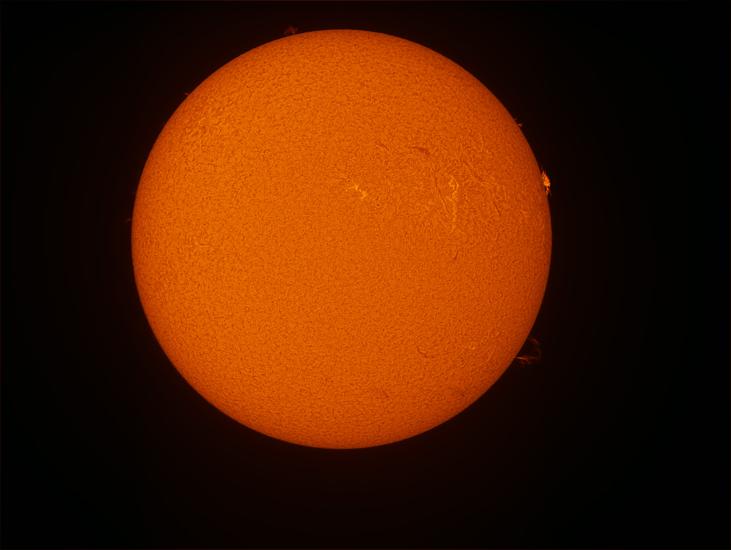 Disk view of the Sun with a prominence of plasma on the right side of the disk.