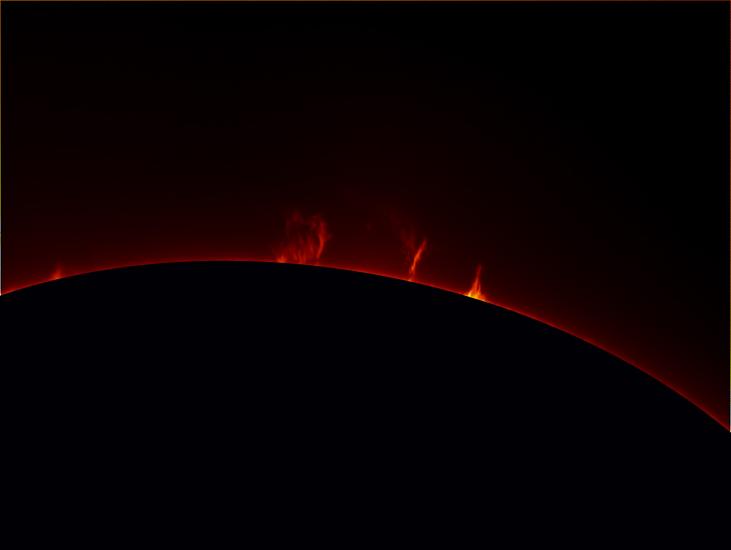 Partial view of the Sun with an emphasis on four prominences of plasma floating away from the Sun.