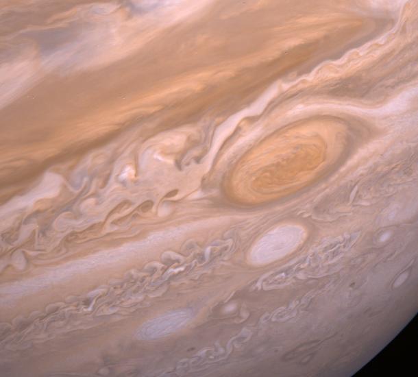 A portion of the gaseous surface of Jupiter with its Great Red Spot on the right side. 