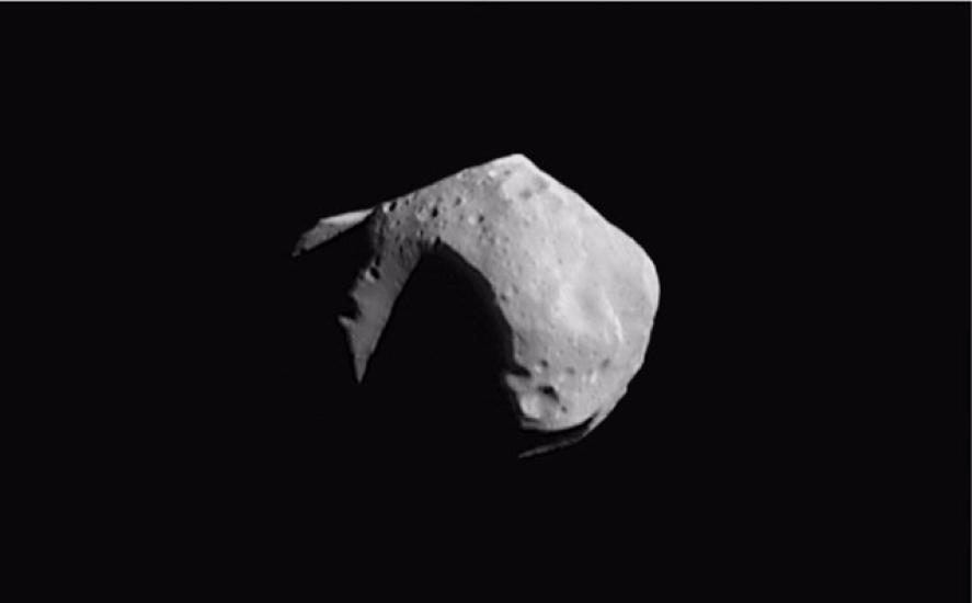 A large asteroid with many visible craters. The left side experiences a large shadow from being in the opposite direction of the sun.