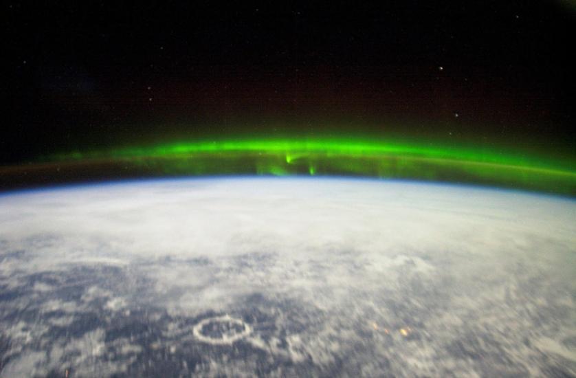 A green reflection of the Aurora Borealis seen from the International Space Station above Earth.