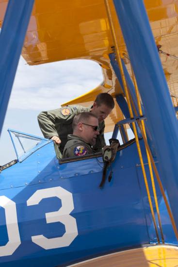 Capt. Matt Quy shows modern military curator Dik Daso how to use safety belts in the cockpit