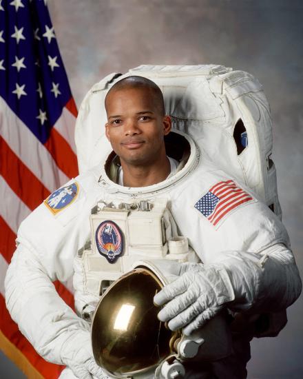 Robert L. Curbeam Jr., an African-American male astronaut, poses formally inside his astronaut suit.