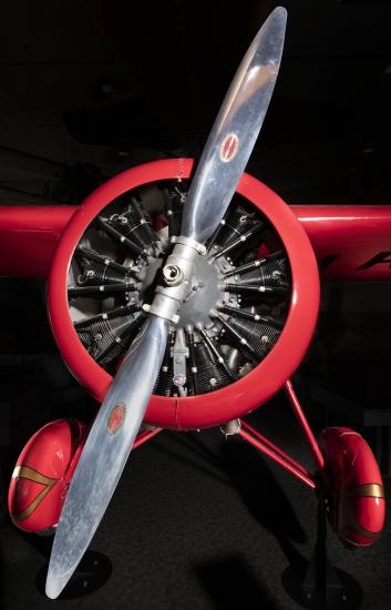 Front engine and silver single-blade propeller on red Amelia Earhart Lockheed Vega 5B aircraft