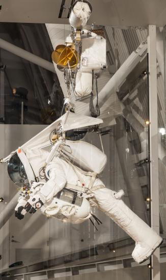 Alan Eustace's white, high altitude jumpsuit on display at the Museum. The suit is hanging in a prone position.