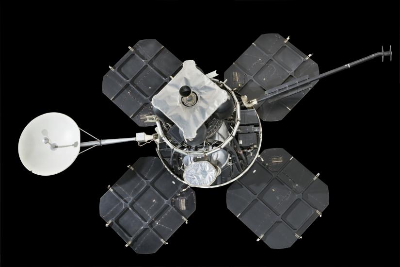 Lunar lander with four square solar panels attached to central instrument box and round satellite dish