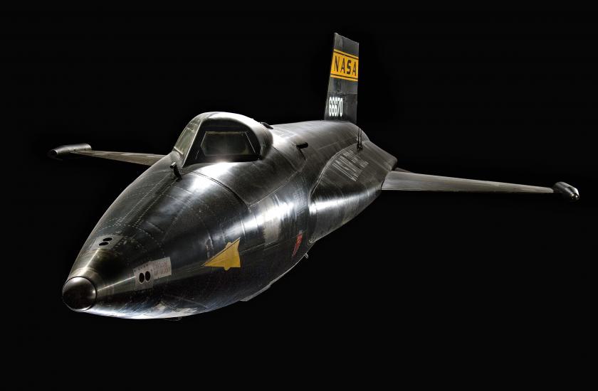 Dark black aircraft with streamlined fuselage and short wings.