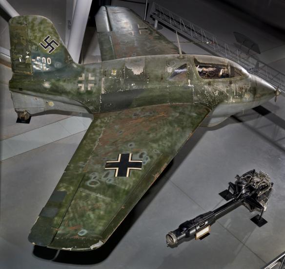 Side view of a green camouflaged German World War II aircraft on display in the Museum.