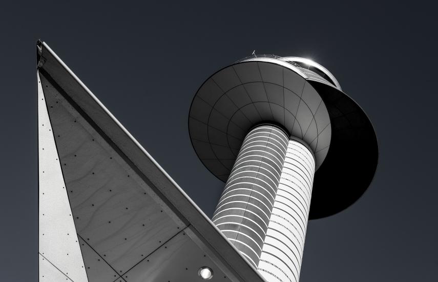 Lower view of an air traffic control tower with a double cylinder-shaped base with two circular sections combined atop the base.