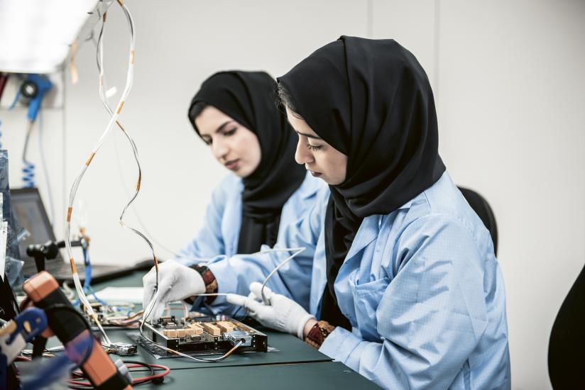 two women work on spacecraft