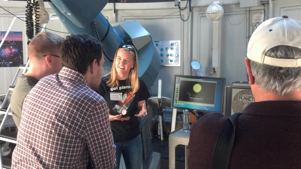 Courtney Dressing, a white female astronomer, chats with Museum visitors inside the museum's observatory.