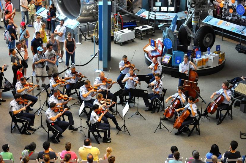 A group of musicians playing string instruments as part of the U.S. Air Force's band perform inside the museum.