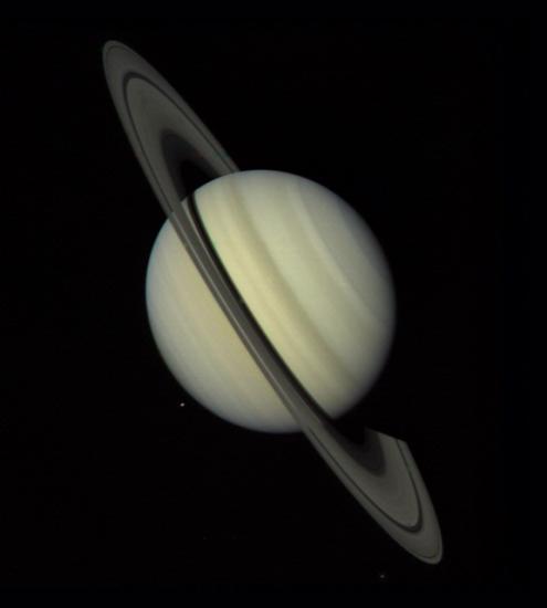 Saturn, a yellow gas planet with large rings surrounding the sphere, as seen via disc view