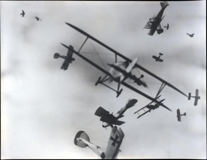 Black and white photo of airplane in the sky. 