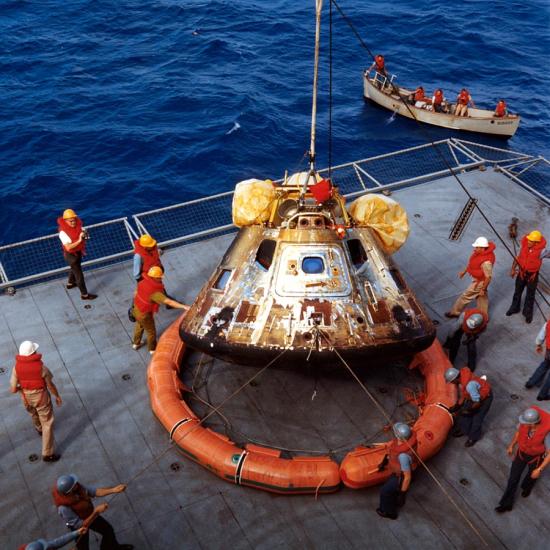 command module lowered onto ship deck at sea