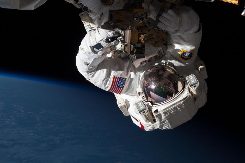 Chris Cassidy, a male astronaut, performs a spacewalk to repair part of the International Space Station. From this perspective, he is upside down.