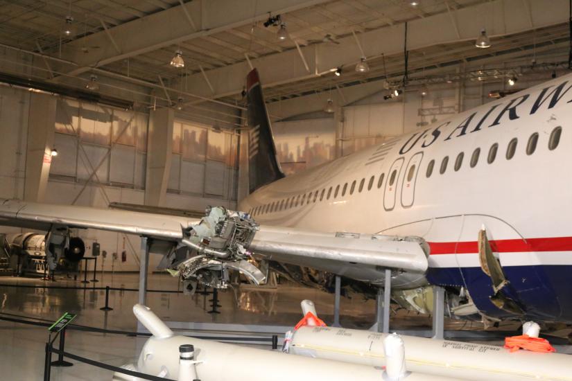 View of the side of the aircraft with wing damage visible. 