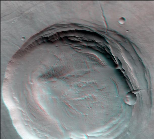 3-D anaglyph of a caldera, a collapsed area of land following a volcanic eruption, atop Biblis Patera, a volcano, on Mars.