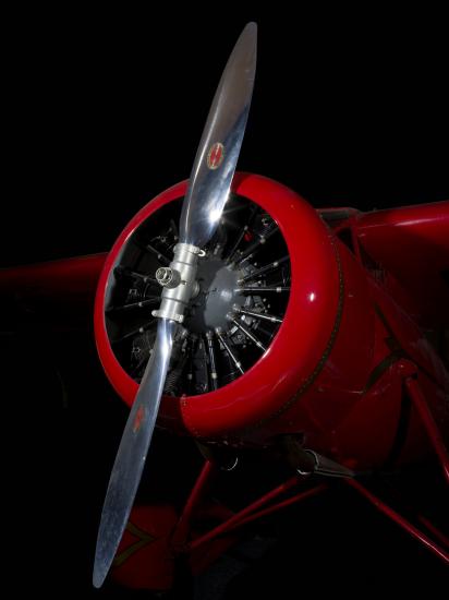 Front engine and silver single-blade propeller on red Amelia Earhart Lockheed Vega 5B aircraft