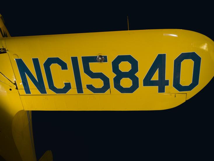 Aircraft registration mark in blue on yellow Staggerwing wing, "NC15840"