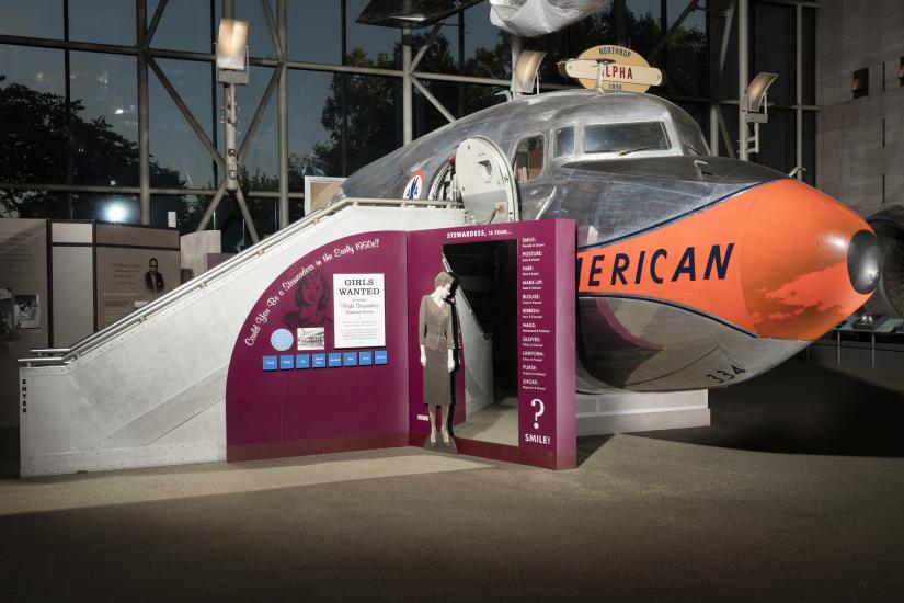 Cutoff of Douglas DC-7 aircraft in museum with exhibit panels next to stairs into aircraft