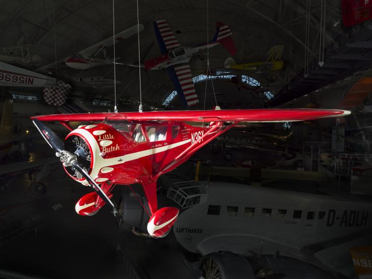 Red monoplane with clipped wings, white trim, and "Little Butch" inscription