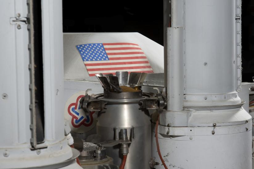 Gas chromatography?mass spectrometry (GCMS) metal part of Viking Mars Lander with American flag sticker in background part of vehicle