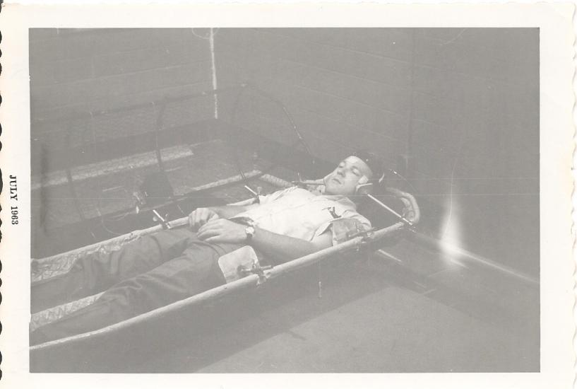 Man lays in a contraption with his head secured by two poles on either side. 