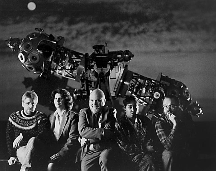 Five people posed in front of Zeiss projector