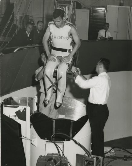 Man in full body restraint being lowered into a centrifuge. 