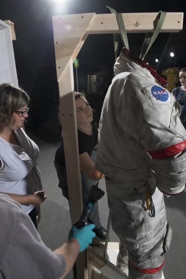 Gene Cernan's Apollo 17 spacesuit being moved out of the exhibit case in the "Apollo to Moon" gallery