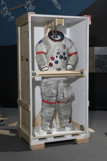 Gene Cernan's Apollo 17 spacesuit being moved out of the exhibit case in the "Apollo to Moon" gallery 