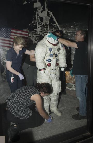 Buzz Aldrin's Apollo 11 spacesuit being moved out of the exhibit case in the "Apollo to Moon" gallery 