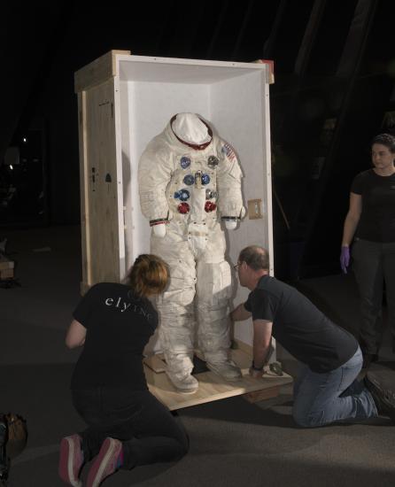 Buzz Aldrin's Apollo 11 spacesuit being moved out of the exhibit case in the "Apollo to Moon" gallery 