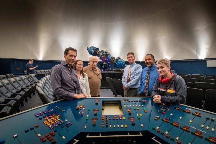 Group of people with Zeiss projector in the background